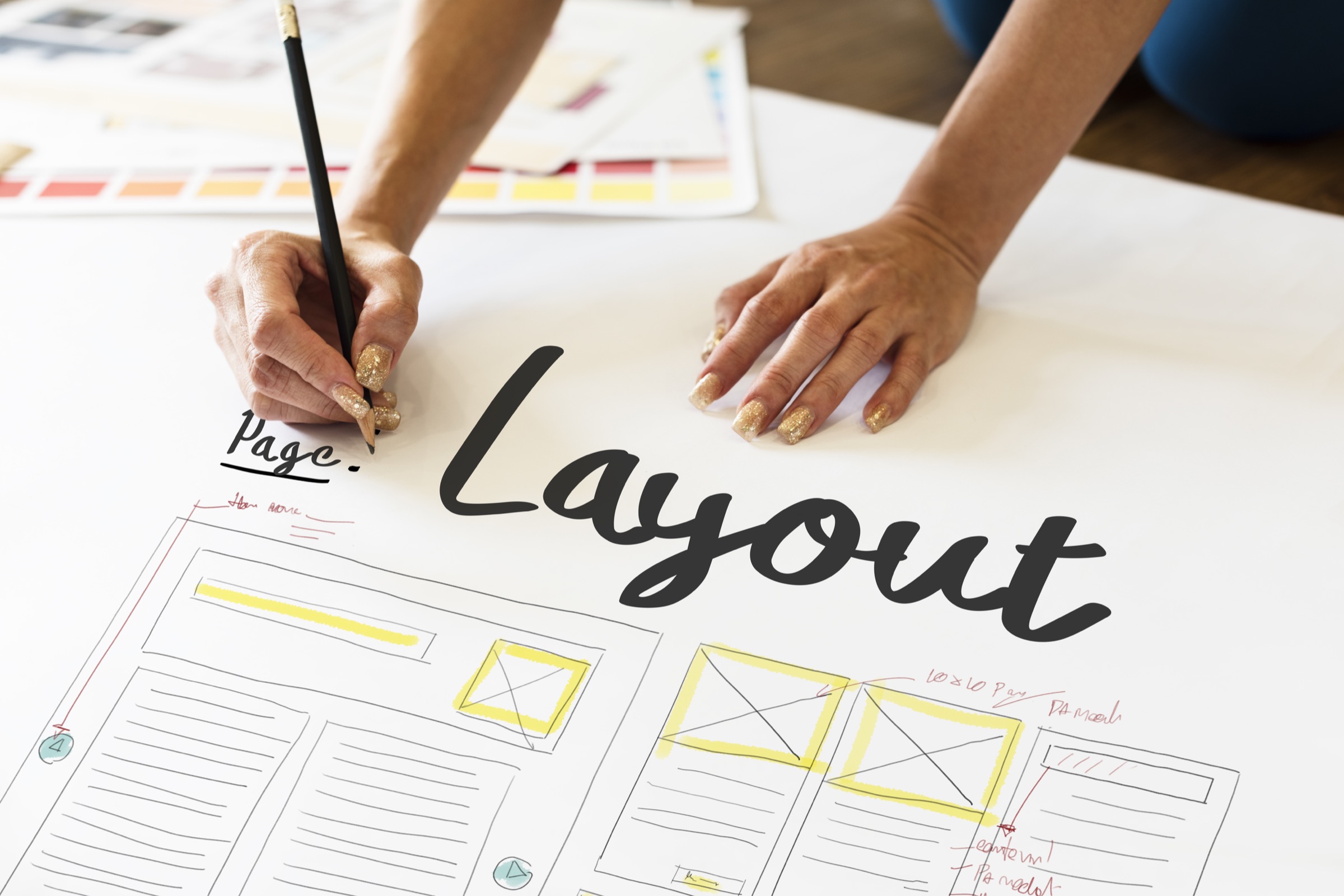 A designer sketching a page layout on paper